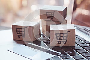 Shopping online. Credit card and cardboard box with a shopping cart logo on laptop keyboard. Shopping service on The online web.