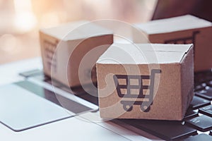 Shopping online. Credit card and cardboard box with a shopping cart logo on laptop keyboard. Shopping service on The online web.