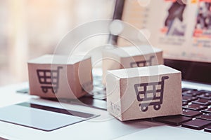 Shopping online. Credit card and cardboard box with a shopping cart logo on laptop keyboard. Shopping service on The online web.