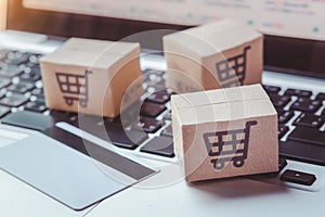 Shopping online. Credit card and cardboard box with a shopping cart logo on laptop keyboard. Shopping service on The online web.