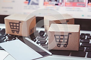 Shopping online. Credit card and cardboard box with a shopping cart logo on laptop keyboard. Shopping service on The online web.