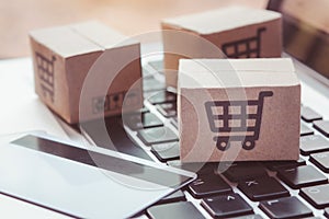 Shopping online. Credit card and cardboard box with a shopping cart logo on laptop keyboard. Shopping service on The online web.