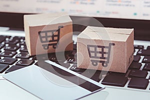 Shopping online. Credit card and cardboard box with a shopping cart logo on laptop keyboard. Shopping service on The online web.