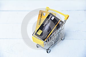 Shopping online with credit card in a shopping cart on the wooden background for online payment at home