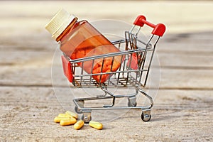 Medical pills and jar in shopping cart