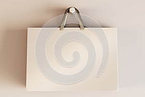 Shopping or present concept with front view on blank beige craft bag with golden handles and place for company logo or advertising