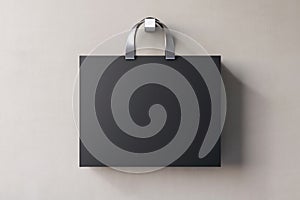 Shopping or present concept with front view on blank black paper bag with silver handles and place for company logo or advertising
