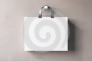 Shopping or present concept with front view on blank white paper bag with silver handles and place for company logo or advertising