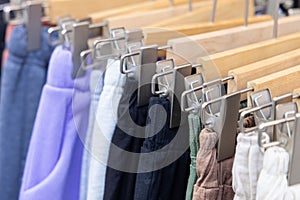 A shopping rank filled with clothes, pants, sports clothes. Bunch of clothes of different colors for sale.