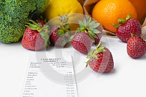 A shopping receipt bill with variety of colorful fresh fruits and vegetables. Raw organic healthy food. Shopping in grocery store