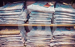 Shopping sale background theme. stack of blue jeans clothes in a shop