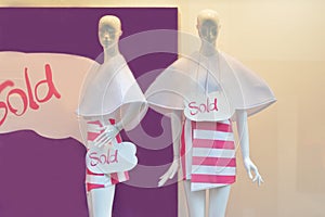 Shopping sale window display with two mannequins