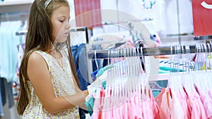 Shopping in the store. children`s clothing department. girl, kid, chooses things in the store. Little fashion-girl