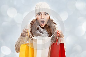 Shopping surprised woman holding bags. Winter sales.