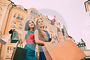Shopping and tourism concept - beautiful girls with shopping bags in ctiy