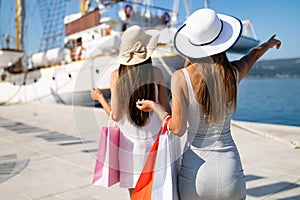 Shopping and tourism, vacation, happy, friends, people concept. Beautiful women with shopping bags