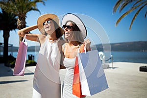 Shopping and tourism, vacation, happy, friends, people concept. Beautiful women with shopping bags