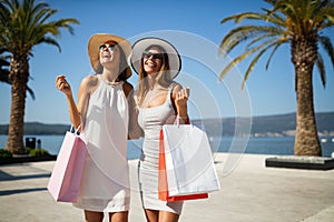 Shopping and tourism, vacation, happy, friends, people concept. Beautiful women with shopping bags