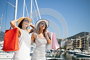 Shopping and tourism, vacation, happy, friends, people concept. Beautiful women with shopping bags