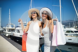 Shopping and tourism, vacation, happy, friends, people concept. Beautiful women with shopping bags