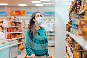 Shopping trip. A young, pretty Caucasian woman with a medical mask on her face selects products in a store. Close up. Product