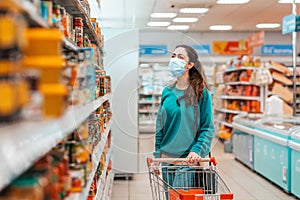 Shopping trip. A young, pretty Caucasian woman with a medical mask on her face selects products in a store. Product purchase