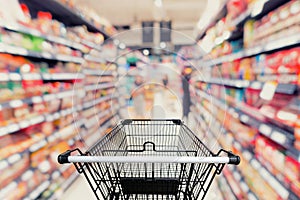 Shopping trolley in department store with goods shelf background