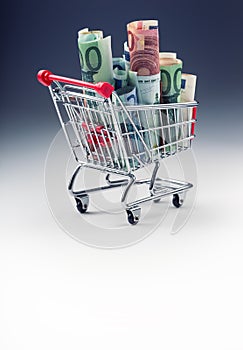 Shopping trolley full of euro money - banknotes - currency. Symbolic example of spending money in shops, or advantageous purchase