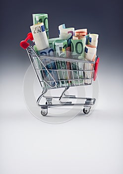 Shopping trolley full of euro money - banknotes - currency. Symbolic example of spending money in shops, or advantageous purchase photo