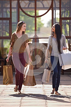 Shopping is a way of life. Two attractive young woman with their shopping bags after a day of retail therapy.