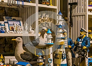 Shopping window of a beach souvenir shop, sculptures of lighthouses, seagulls and sailors