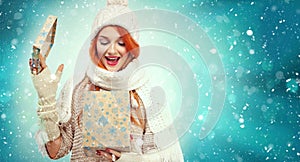 Shopping woman holding gift box on winter background with snow in black friday, Christmas and New Year holidays. Sale
