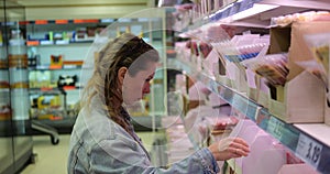 Shopping woman select precooked pre-sliced meat product for breakfast sandwich