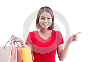 Shopping woman smiling joyful and happy holding shopping bags pointing