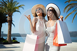 Shopping women happy holding shopping bags walking having fun laughing in street