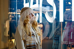 Shopping. A young girl looks at shop window