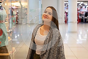 Shopping A young girl looks at shop windows, chooses gifts in a mall