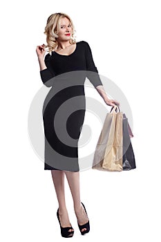 Shopping young woman holding bags isolated on white studio background. Love fashion and sales. Happy blond girl in black luxury gl