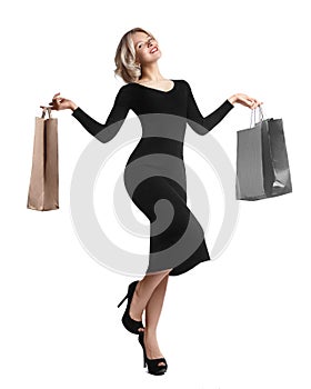 Shopping young woman holding bags isolated on white studio background. Love fashion and sales. Happy blond girl in black luxury gl