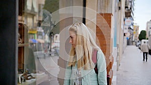 Shopping - young woman looking in a shop window