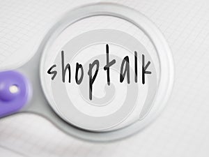 Shoptalk title text through a magnifying glass on a notepad background photo