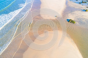 shore of a beach with a fresh water stream, aerial view from drone