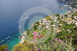 The shore of Capri island viewed from the coast, representing a part of green land and the blue sea, photo