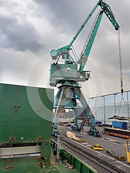 Shore crane loading containers in freight ship.