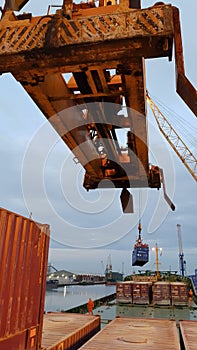 Shore crane loading containers in freight ship