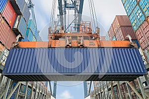 Shore crane loading containers in freight ship