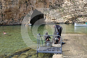 Shore diving, scuba diver entering the sea on a ladder, most of dive sites are reachable from shore,