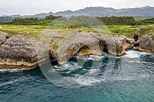 Shore with geological caves made by waves by jesters bufones of arenillas, Spain near city Llanes in August 2023