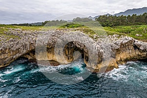 Shore with geological caves made by waves by jesters bufones of arenillas, Spain near city Llanes in August 2023