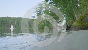 Shore of lake with white boat background. Row Boat floating, anchored off shore, on a lake with perfect reflection of